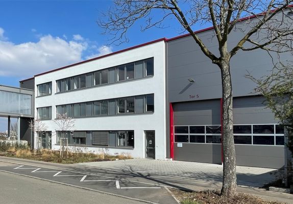 Gewerbegebäude mit Werkstatttoren – Pfeil Bauträger